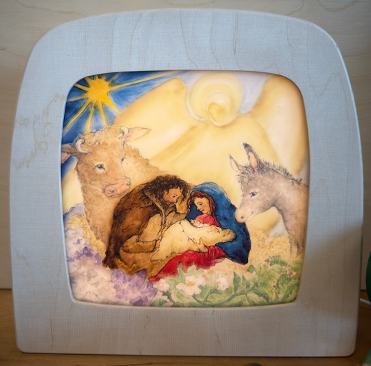 Decorative lamp silhouette with nativity scene design featuring a  guiding star, Mary and Joseph with new baby Jesus, an angel, ox and donkey.