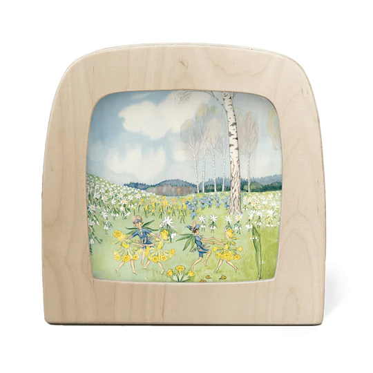 A wooden silhouette screen featuring an illustration of fairy folk dancing together in early Spring