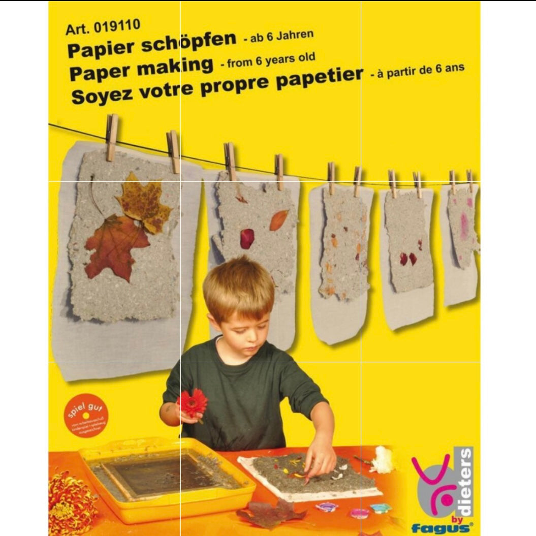 Box for paper-making kit showing child making paper and handmade paper hanging, on a yellow background