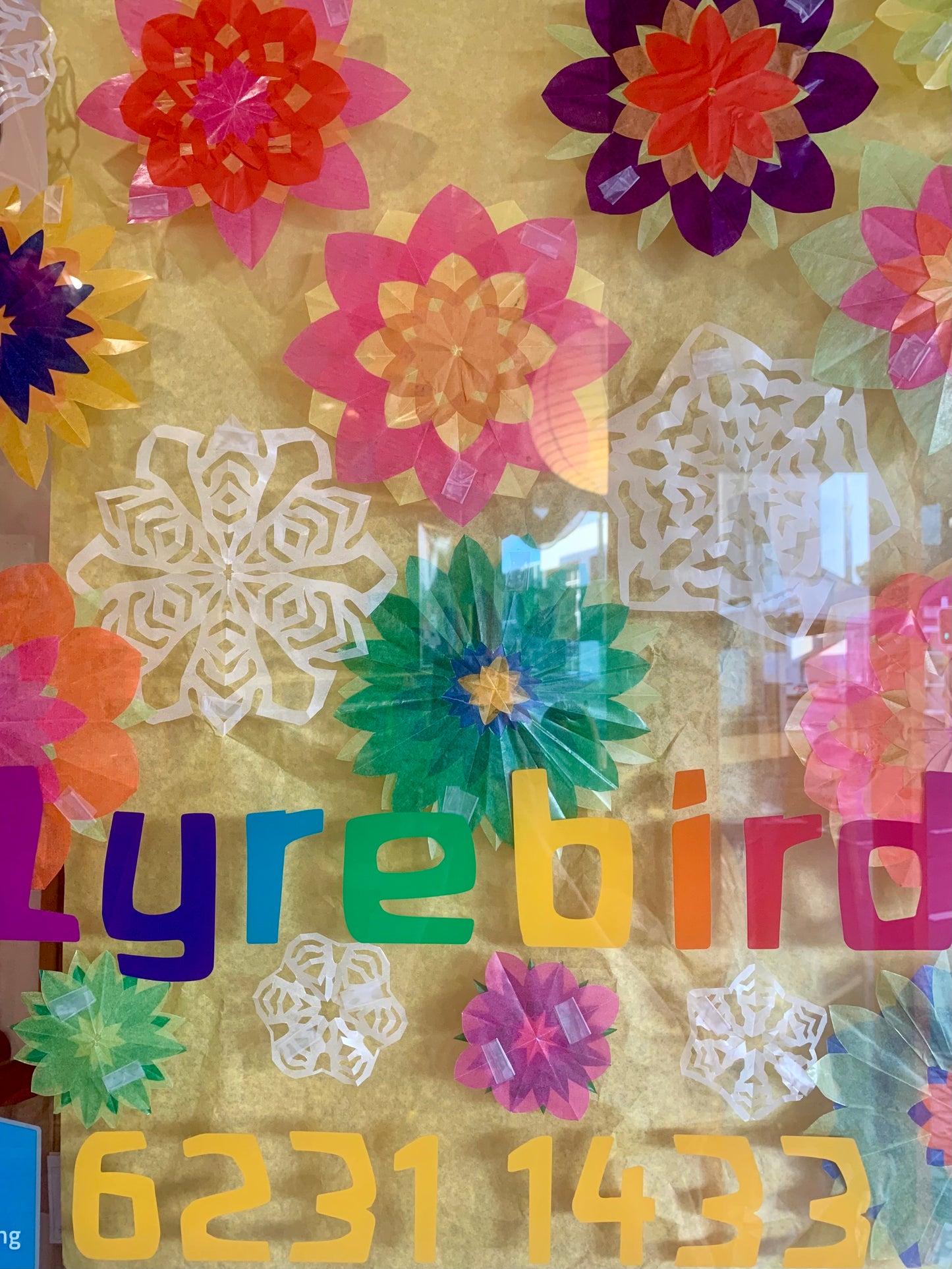 Pretty window flowers made from colourful layered kite paper  and paper snowflakes