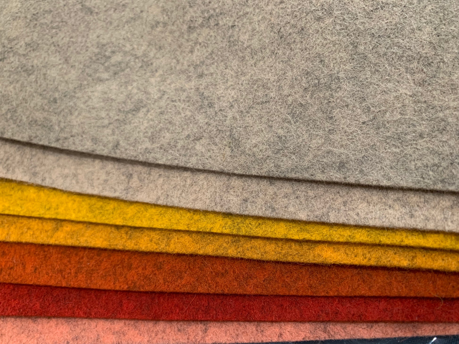 a selection of seven shades of mottled felt in rewds and orange tones