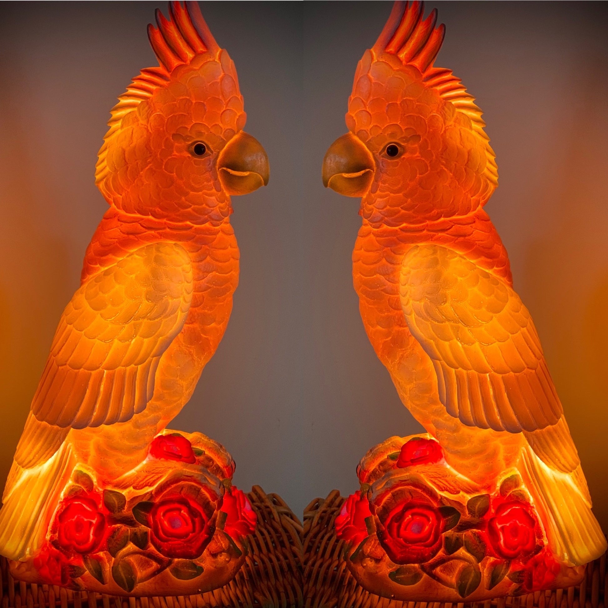 Two pink cockatoo shaped lamps lit up with a gentle pink glow.