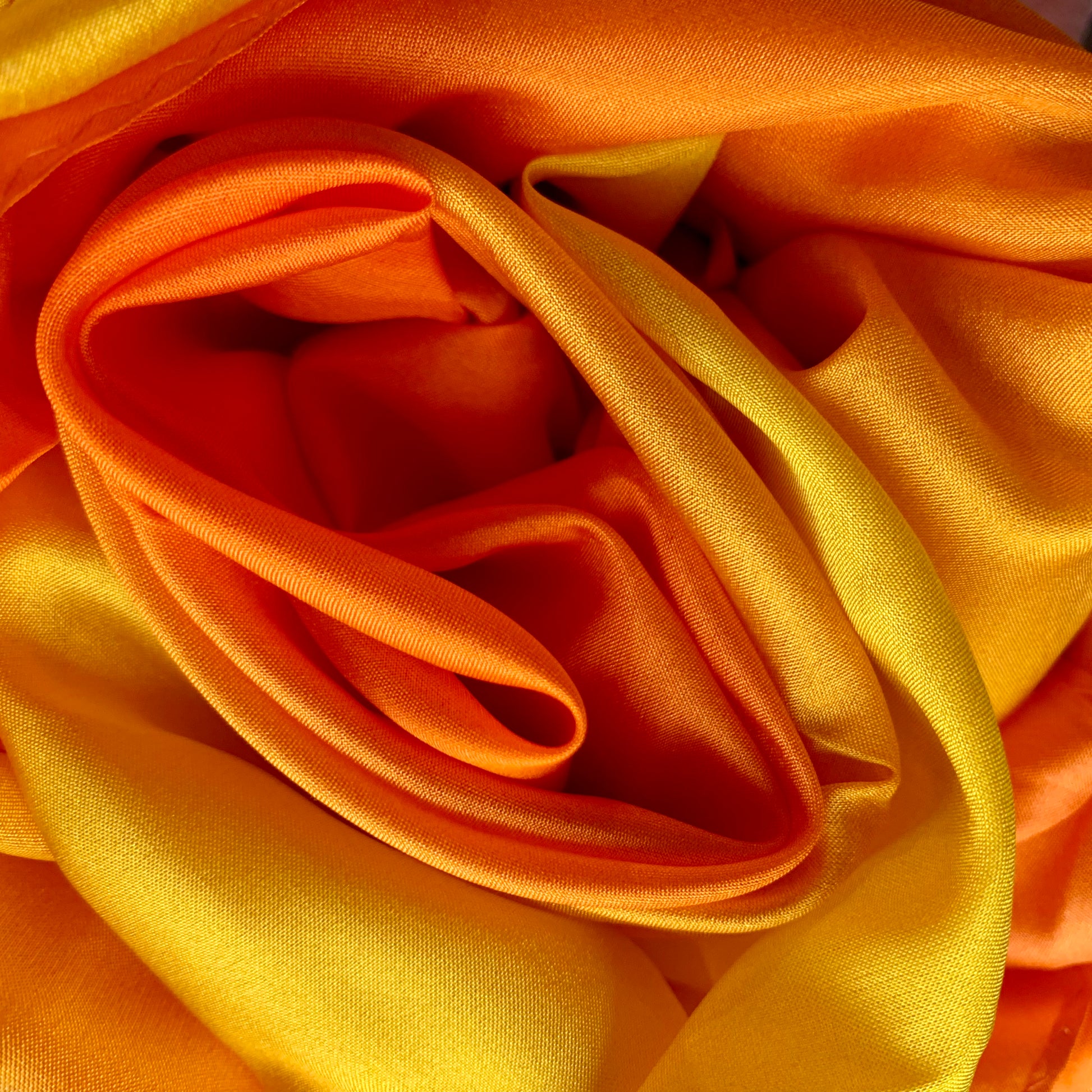 Close-up of orange and yellow silk fabric with a soft texture