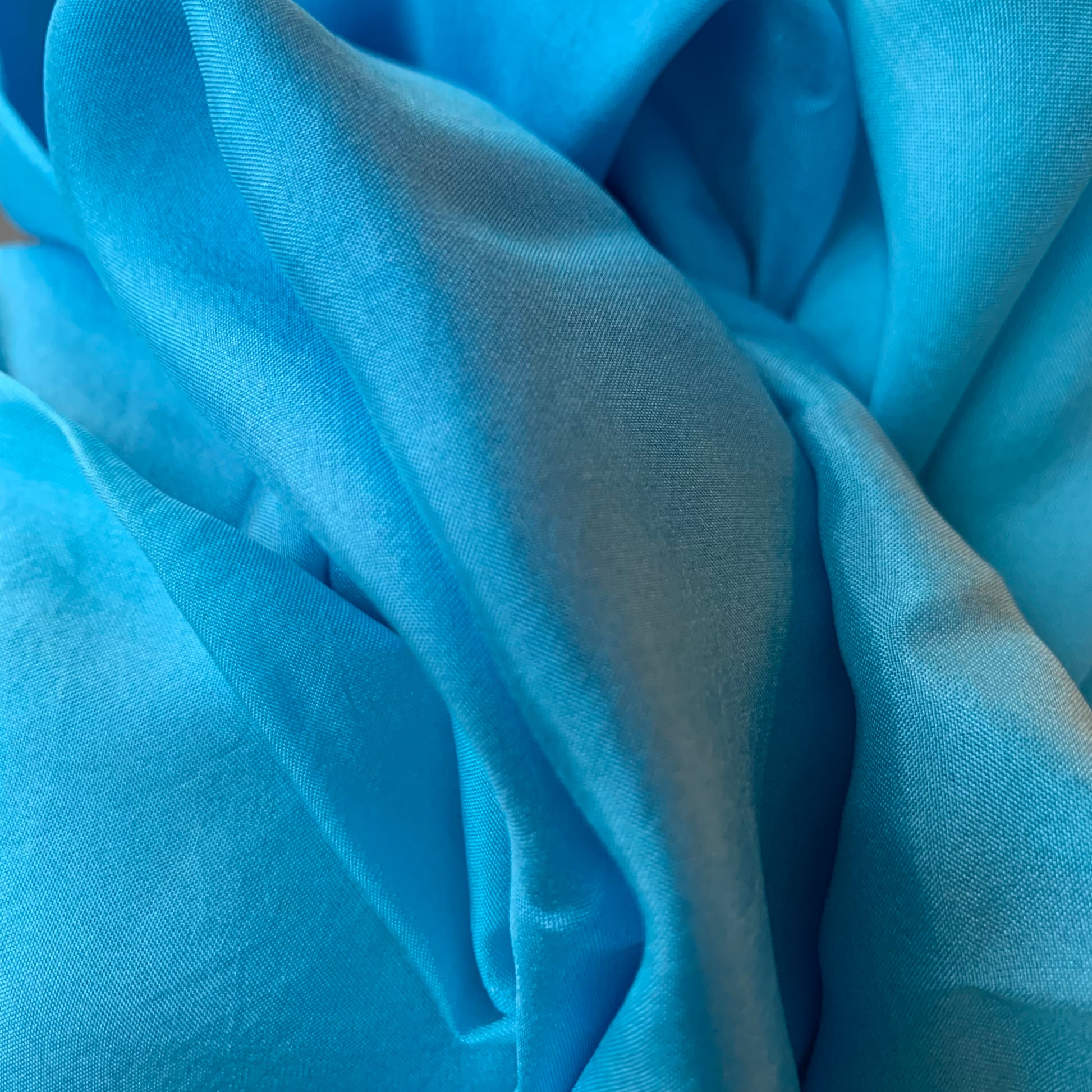 Close-up of variegated sof blue silk fabric with folds