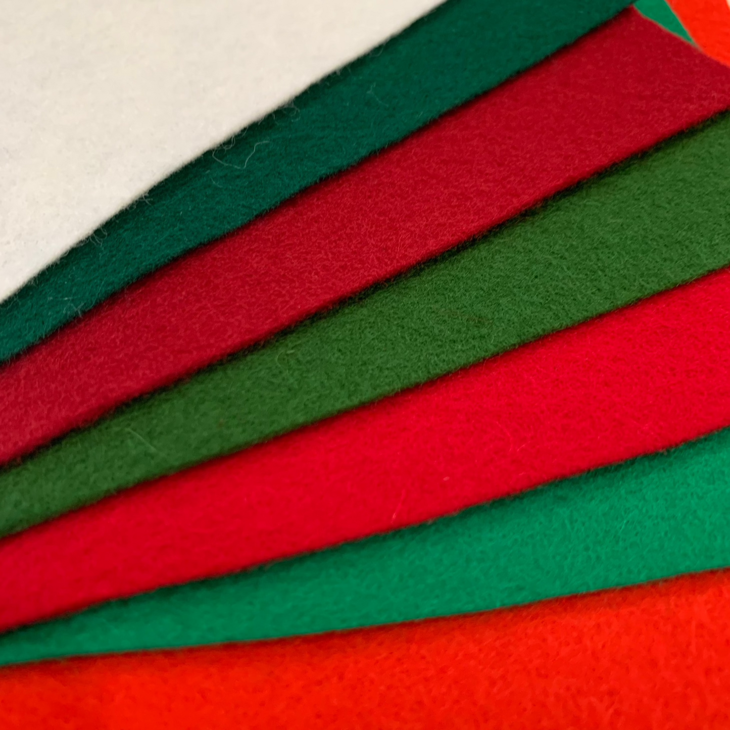 A selection of wool felt in 7 Christmas shades: 3 reds, 3 greens, one soft white