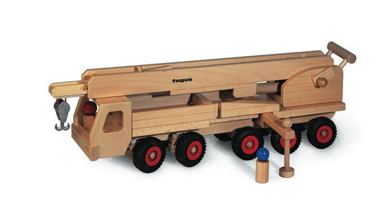 Wooden toy crane trucknwith red wheels on a white background
