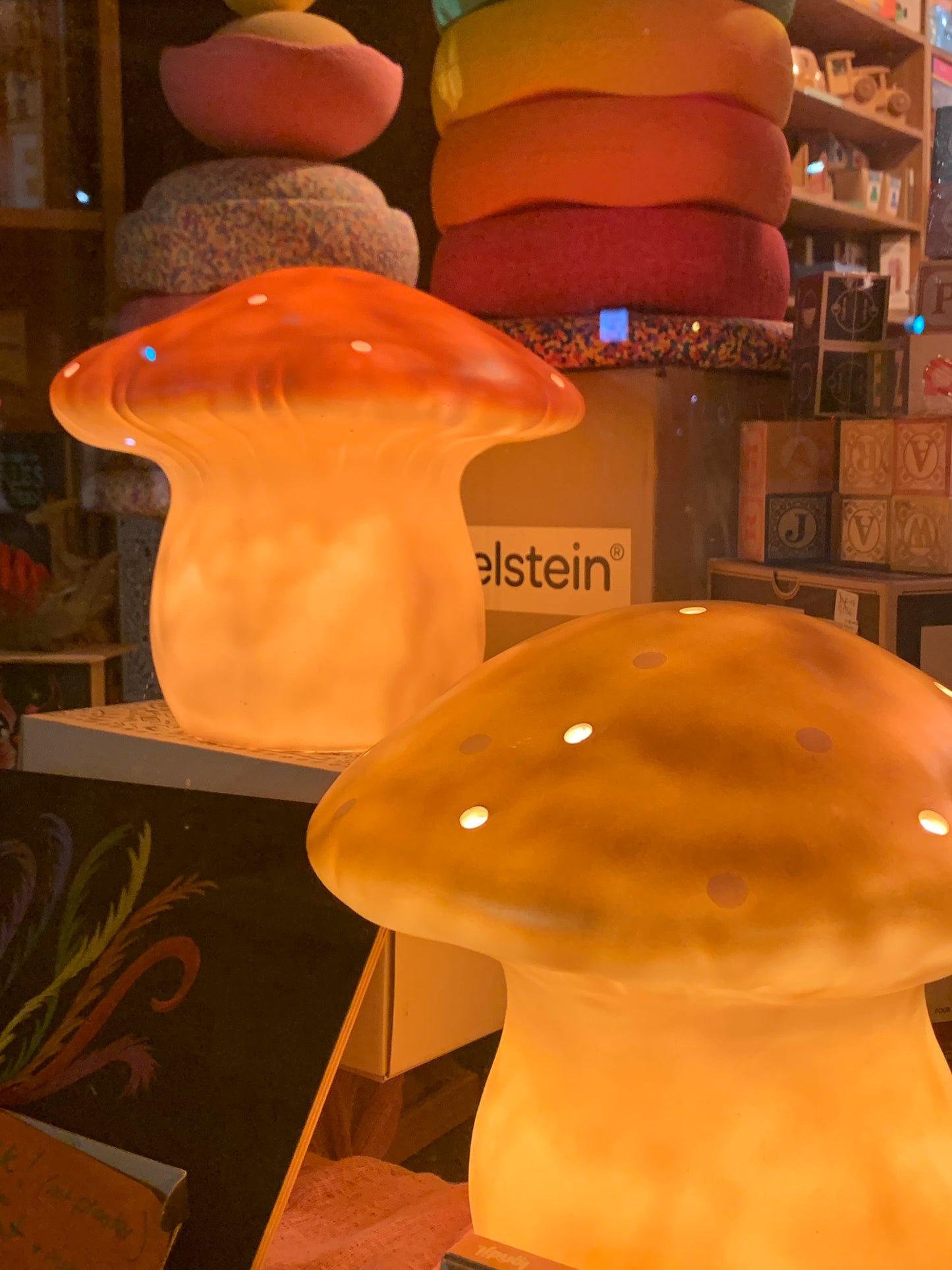 medium mushroom lamps lit up: terracotta left rear, gold front right