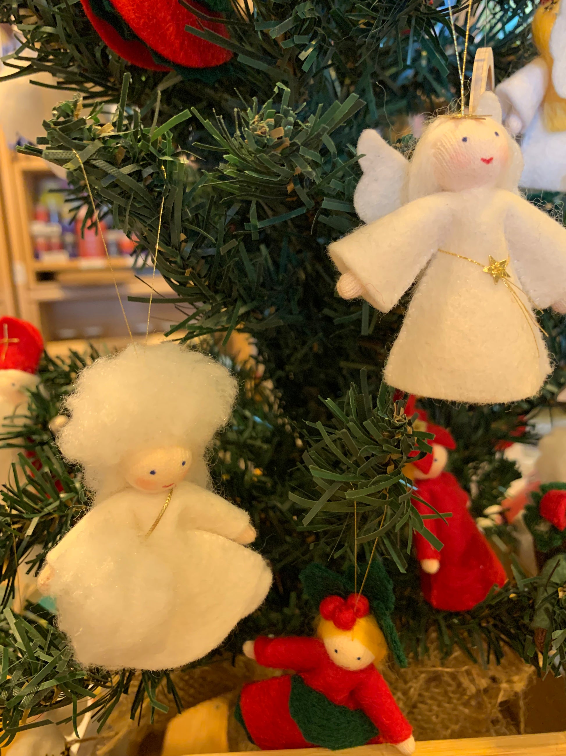 Christmas tree felt ornaments, including fairies hagng in a Christmas tree, with a focus on white and red colors, representing the festive season.