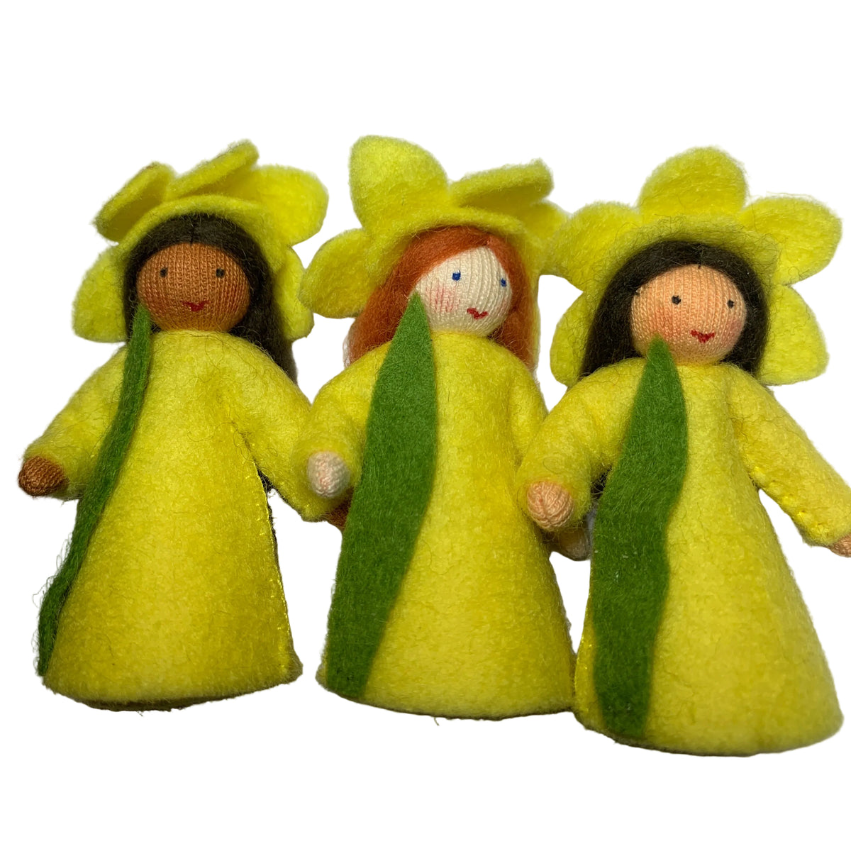 Three small handmade felt daffodil flower dolls standing side by side on a white surface. Each doll wears a yellow flower-shaped hat and a yellow dress with a green center panel, with embroidered faces and dark hair.