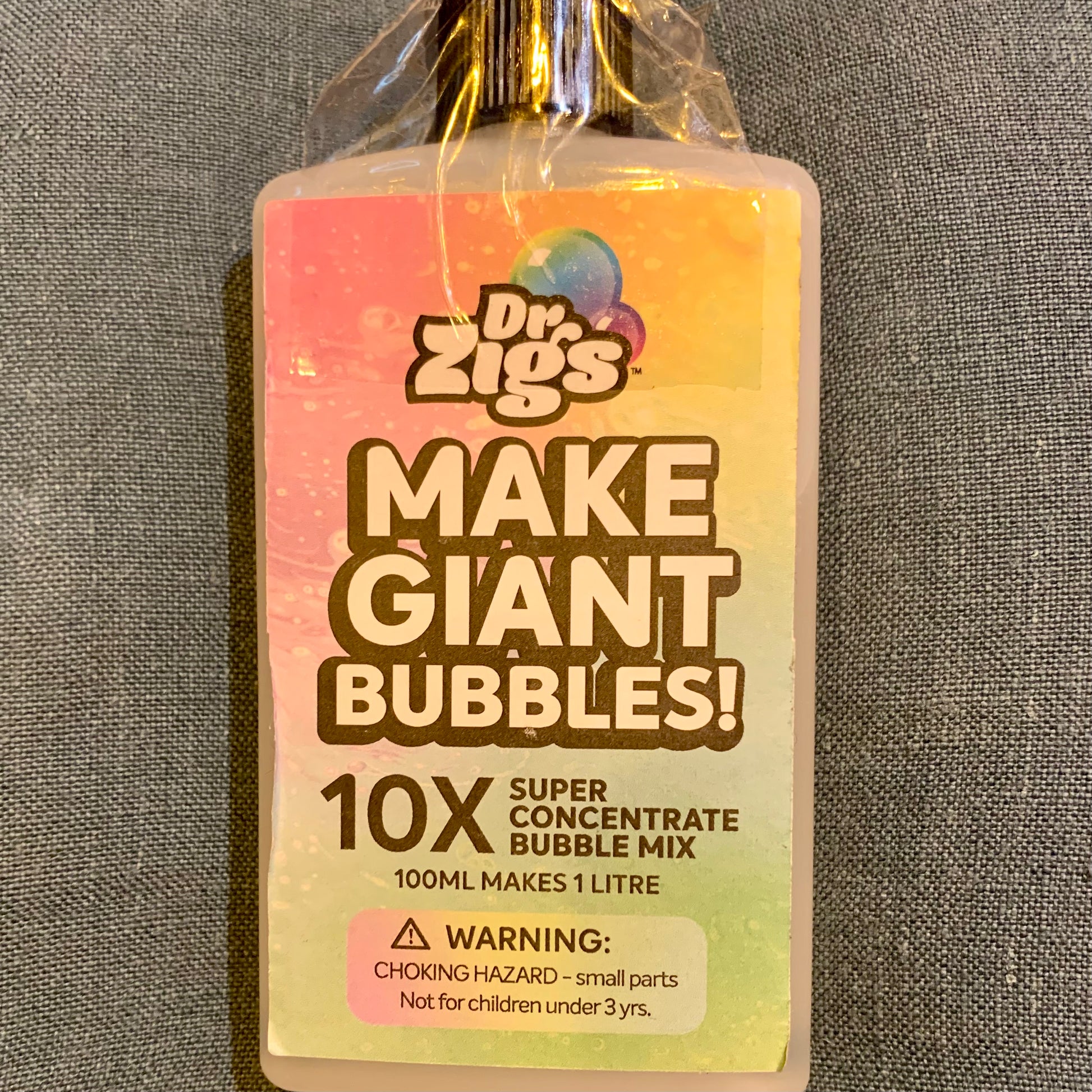 Dr. Zig's 100ml refil bubble mix bottle with label on a grey background