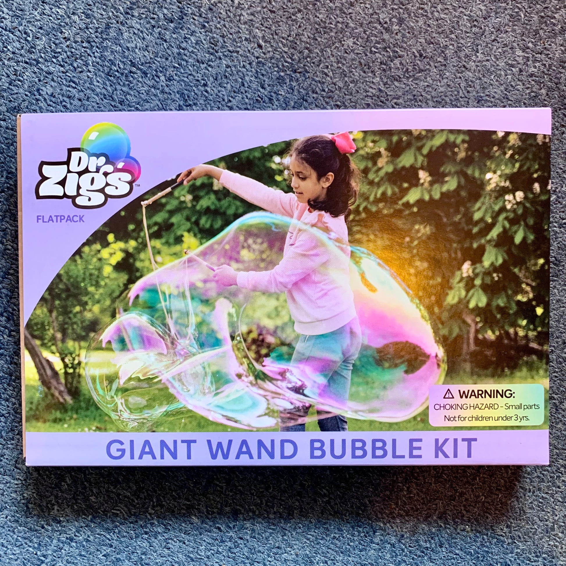 Dr. Zigs Giant Wand Bubble Kit label with a child playing making giant bubbles outdoors.