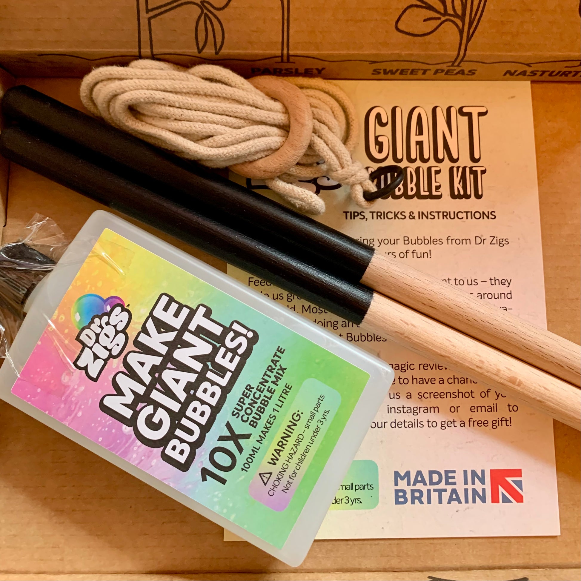 Dr. Zigs Giant bubble kit with sticks, bubble mix, and instructions on a grey surface.