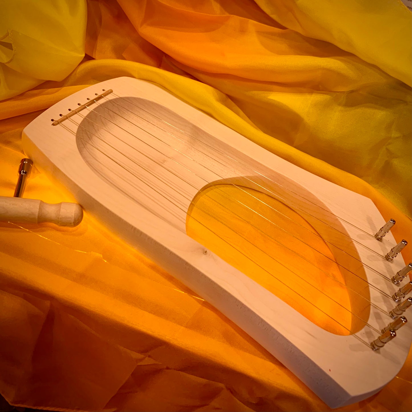 Wooden lyre harp with fine strings on a silk of autumn shades 