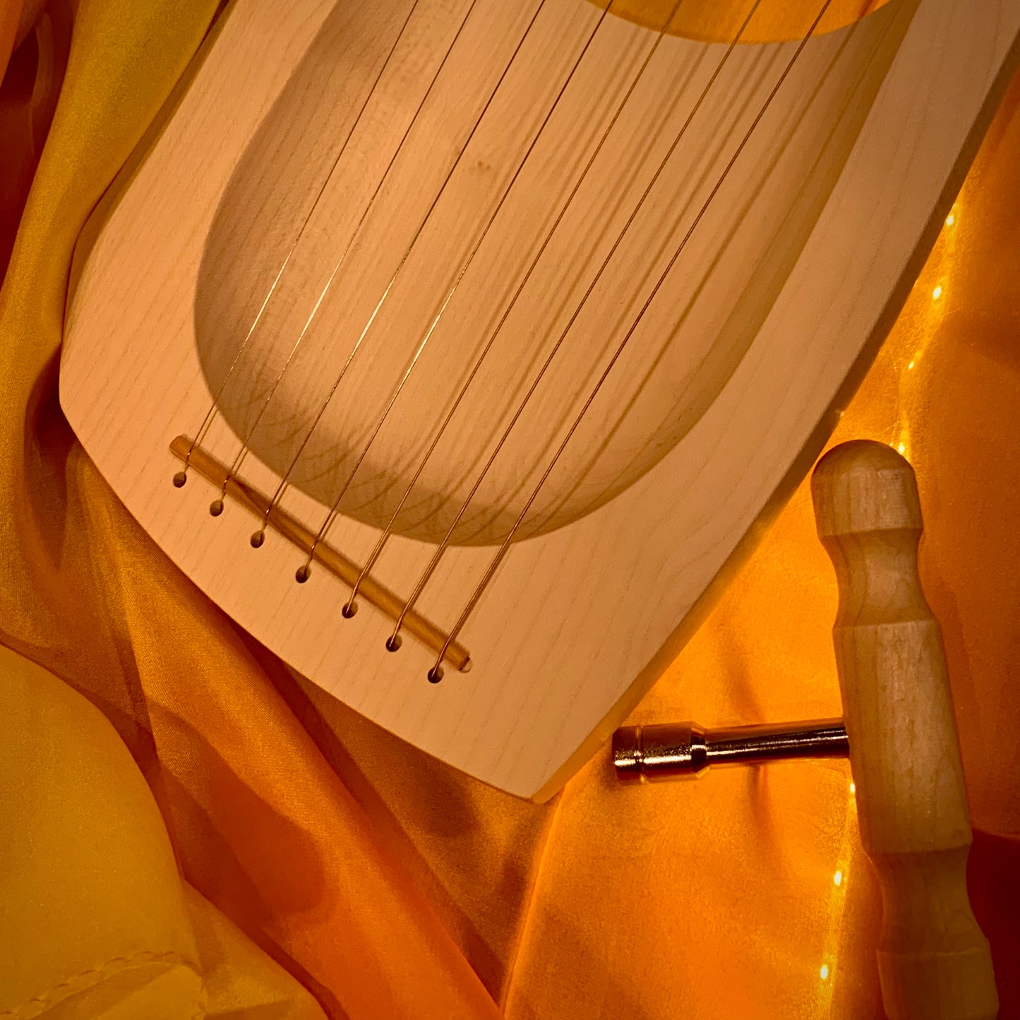Wooden Lyre showing the bottom section and tuning wrench 