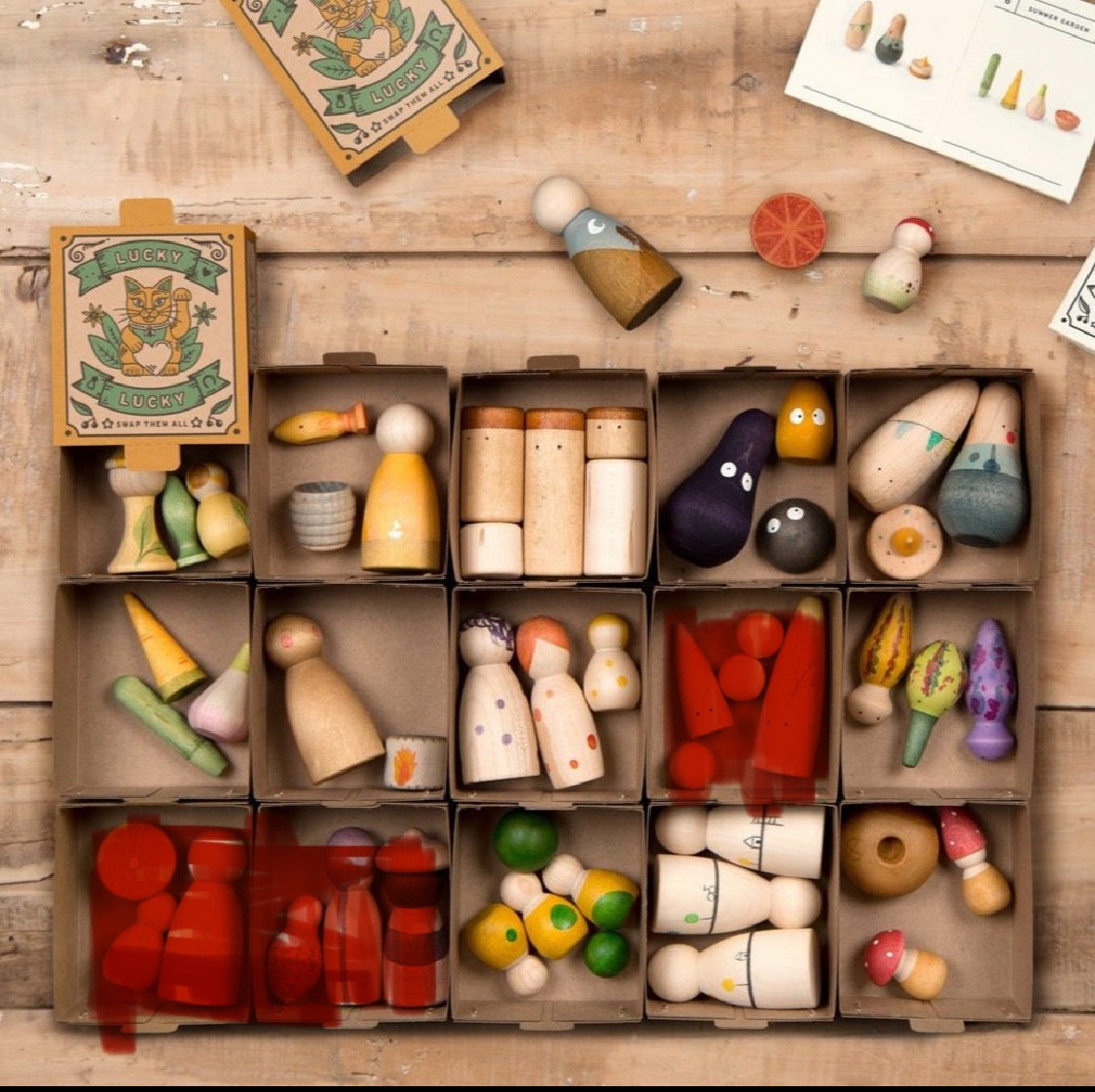 Collection of wooden toys in open boxes on a wooden surface