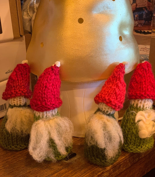 Adorable little hand knitted Steiner gnomes for display on a seasonal nature table with a Gold mushroom lamp in the background