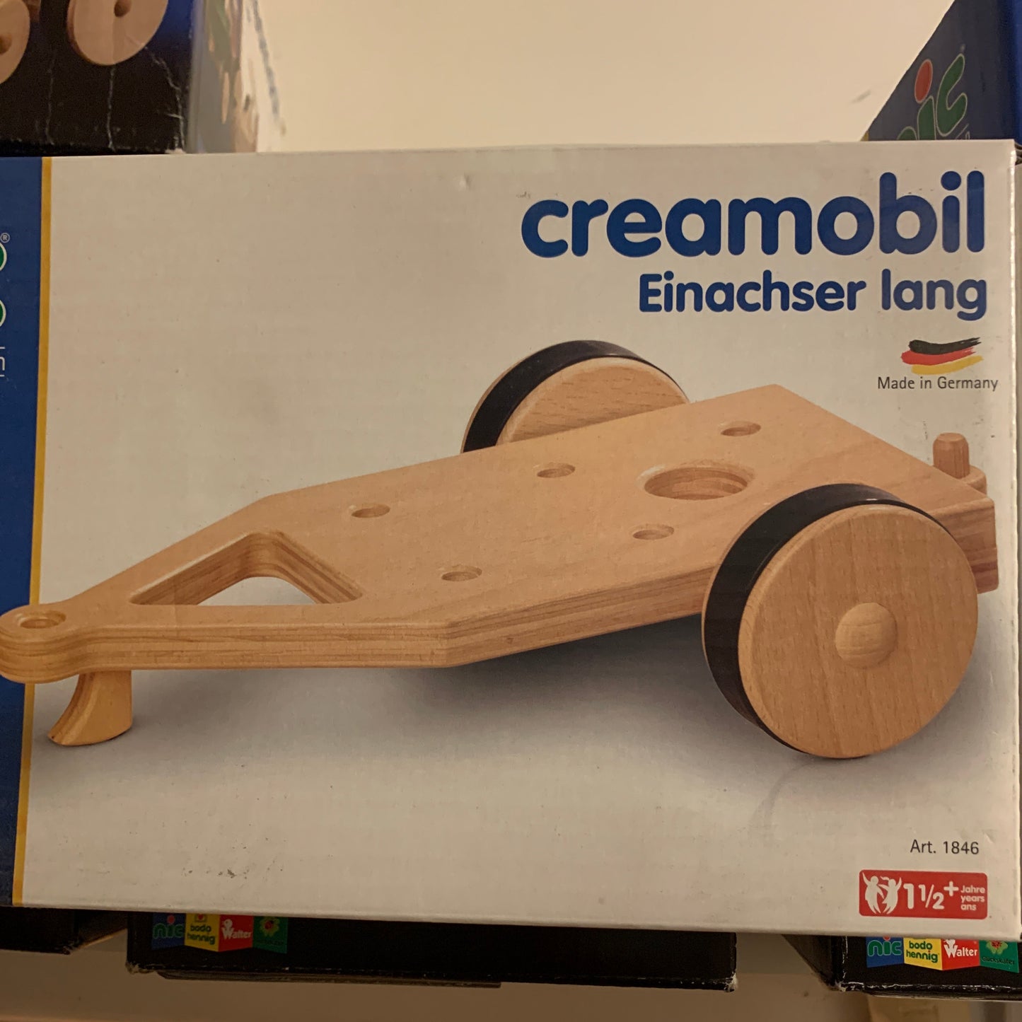 Wooden toy creamobile on a box with 'creamobil' branding in a store setting