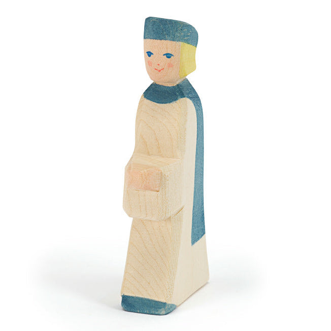 Wooden figurine of a page boy with blue hat and white gown with blue cape  on a white background