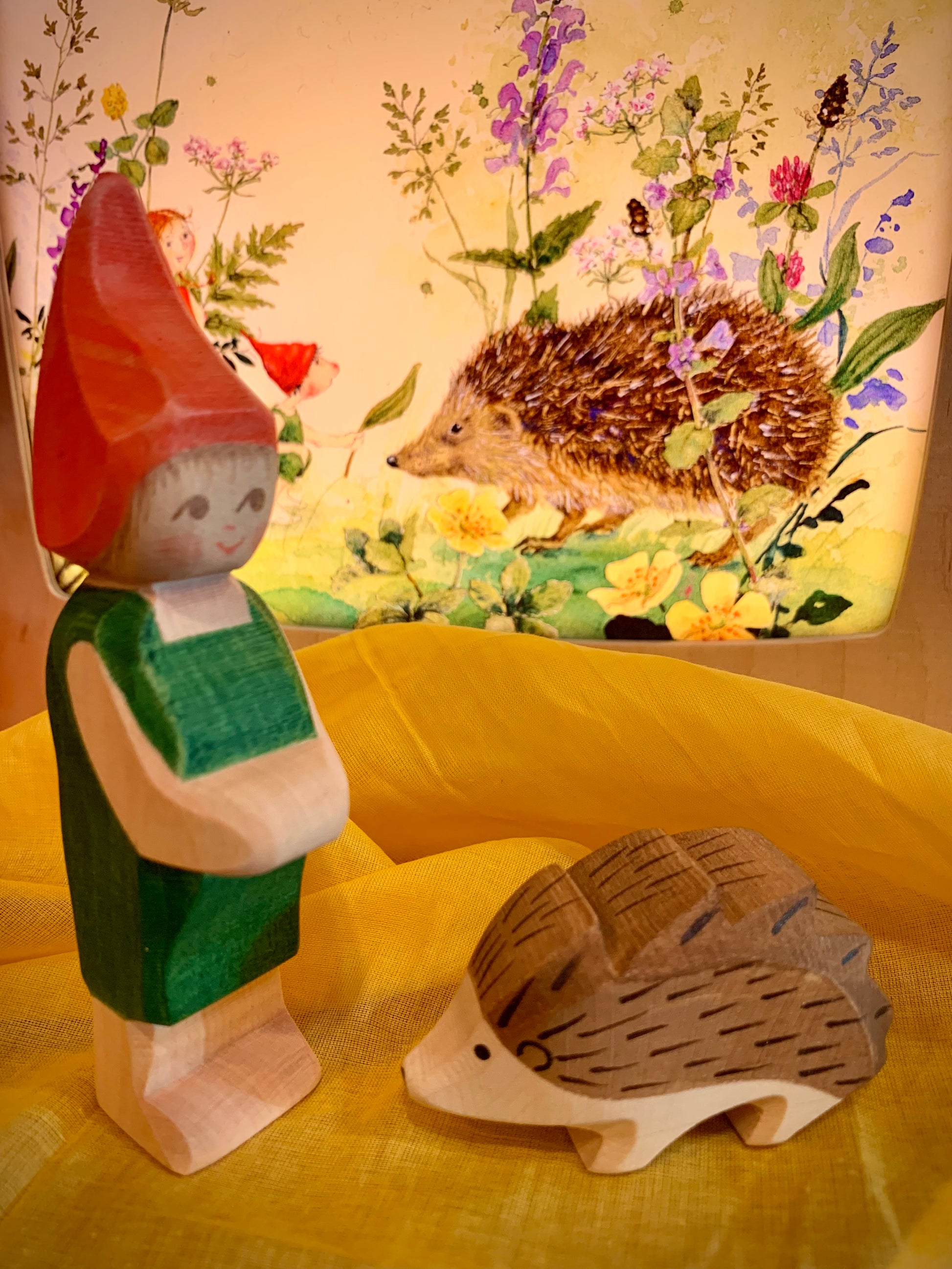Wooden elf and hedgehog figures with a lamp in background