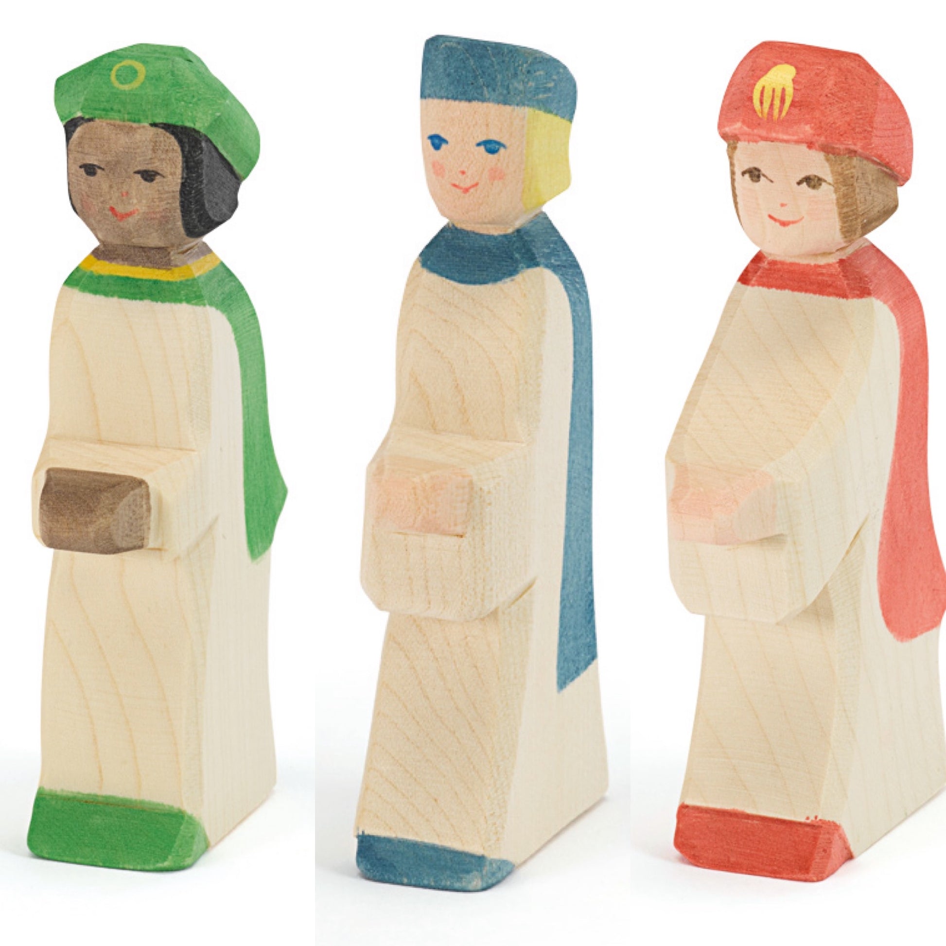 Three wooden figurines of page boys with colorful hats on a white background