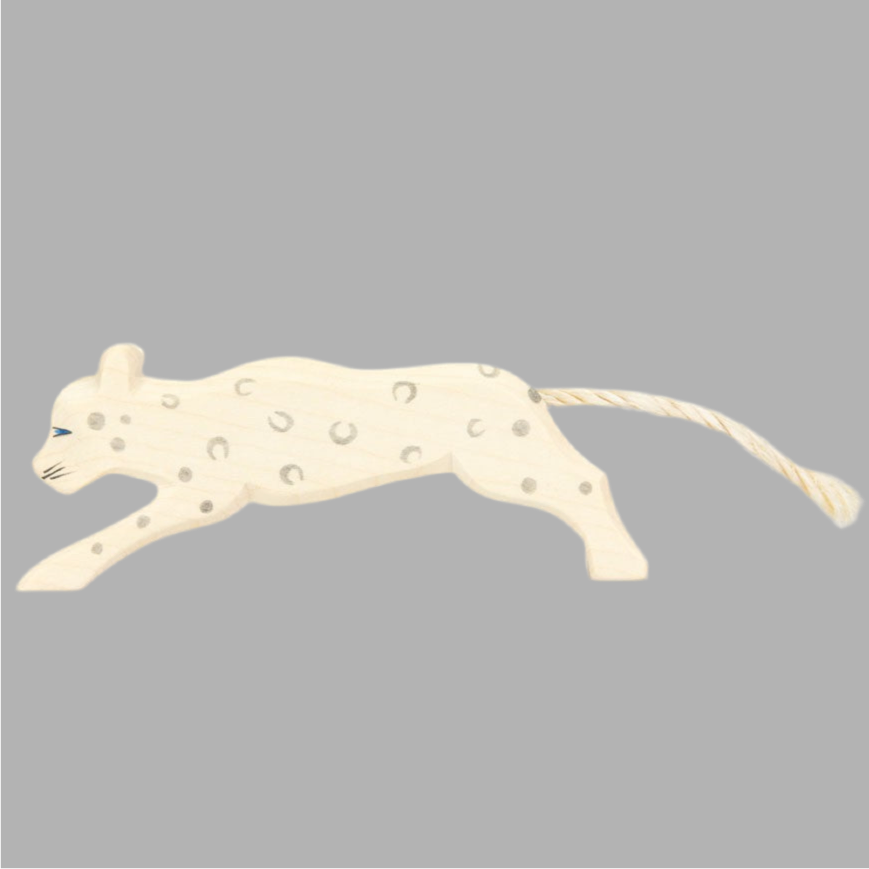 Wooden snow leopard figure with rope tail on grey background