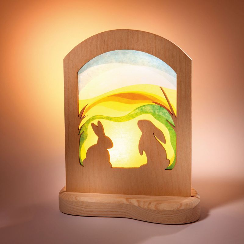 Wooden lamp with rabbit silhouette design on a warm background