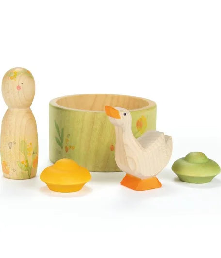 Set of wooden toys including a duck, a cup, and two small figures on a white background