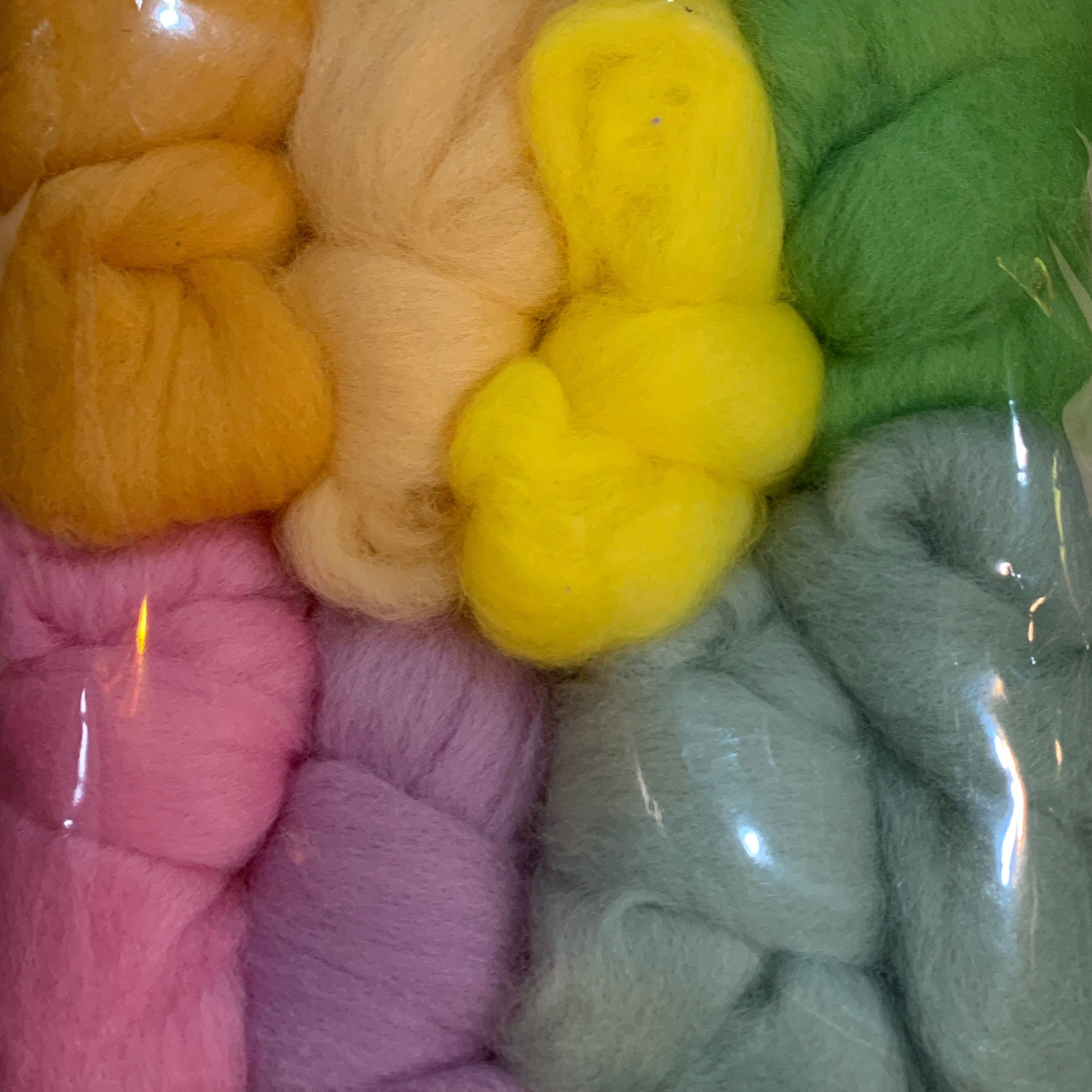 Set of pastel shades of wool fleece bundles in a clear plastic bag
