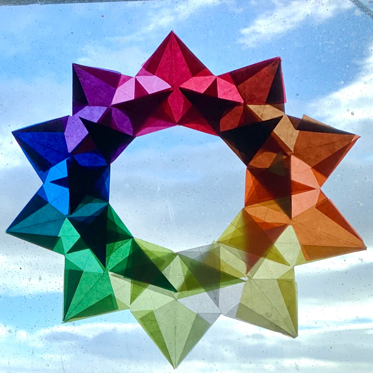 a beautiful kite paper wreath made from cut and folded five pointed stars glued together 