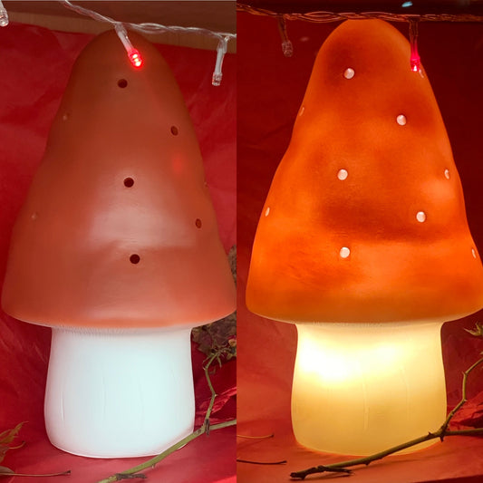 Mushroom-shaped lamp with a white base on a red background