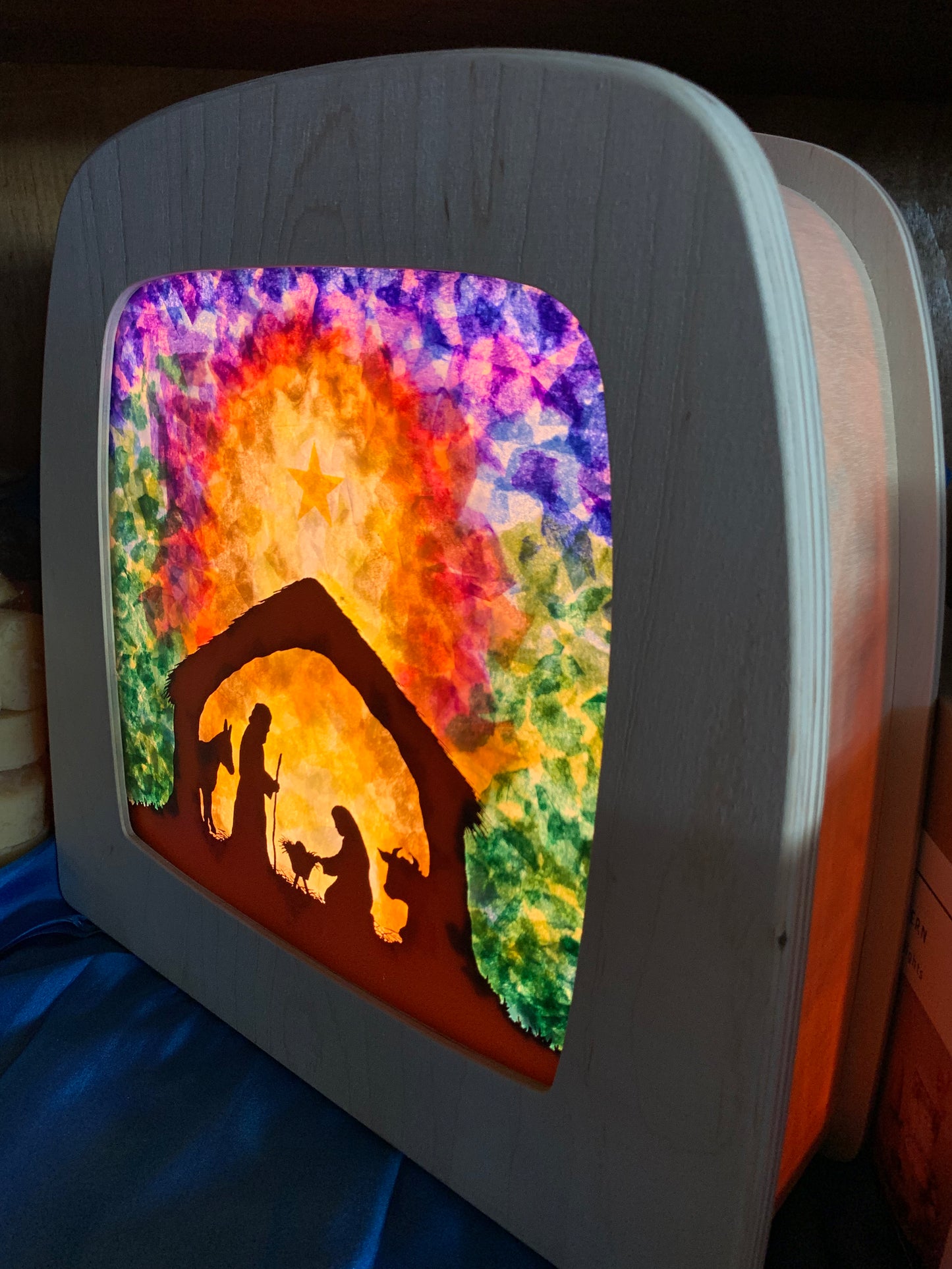 A wooden lamp with a kit made colourful nativity scene