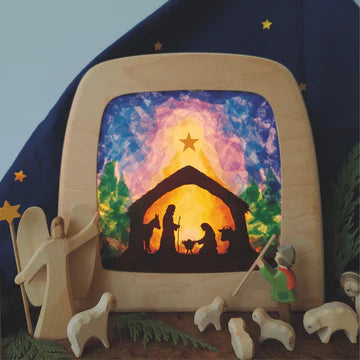 Silhouette nativity scene with starry sky and wooden figures on a dark blue background