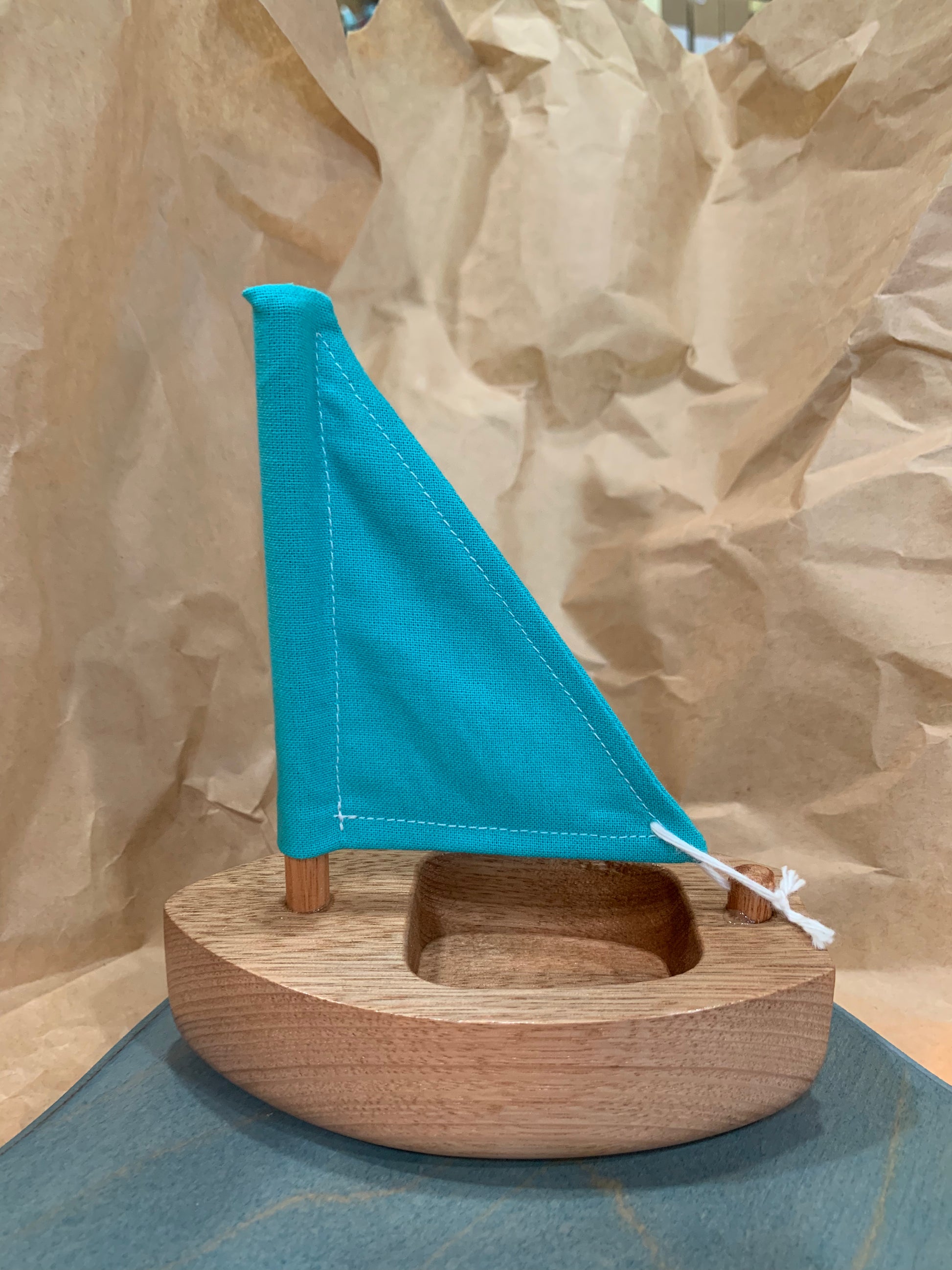 wooden boat with blue sail