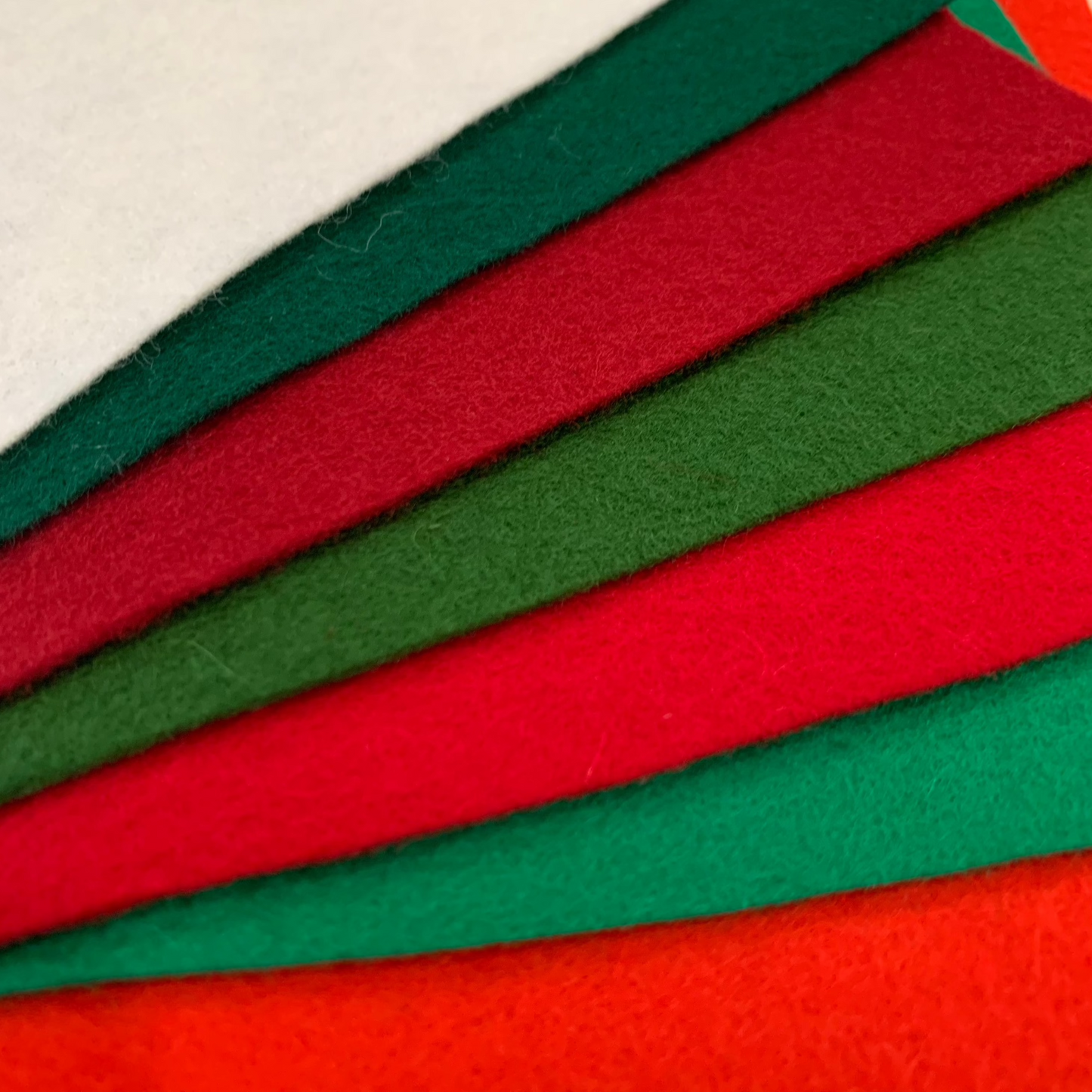 a selection of wool felt in 7 Christmas shades: 3 reds, 3 greens, one soft white