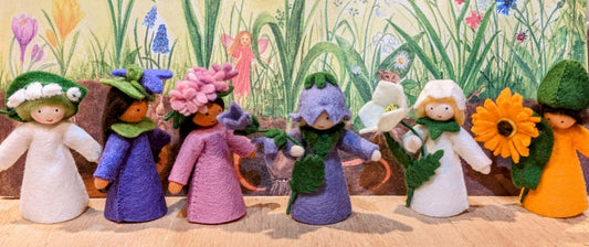 Row of pretty felt fairys with a hand drawn crayon floral background 